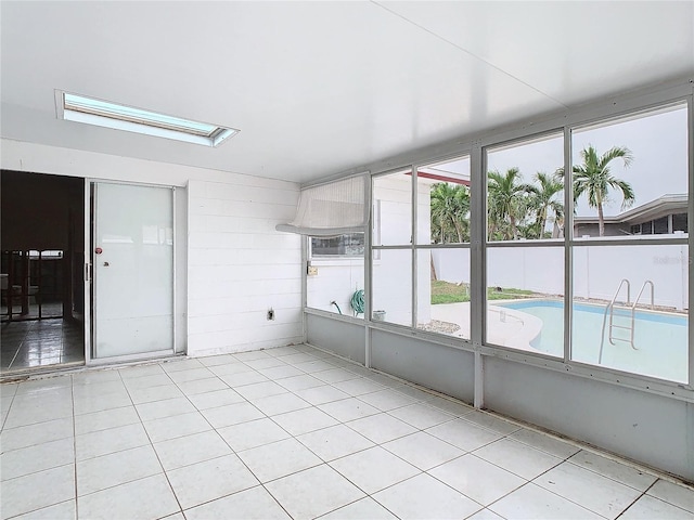 unfurnished sunroom featuring a skylight