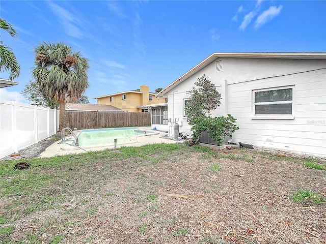 view of yard featuring a fenced in pool and a sunroom