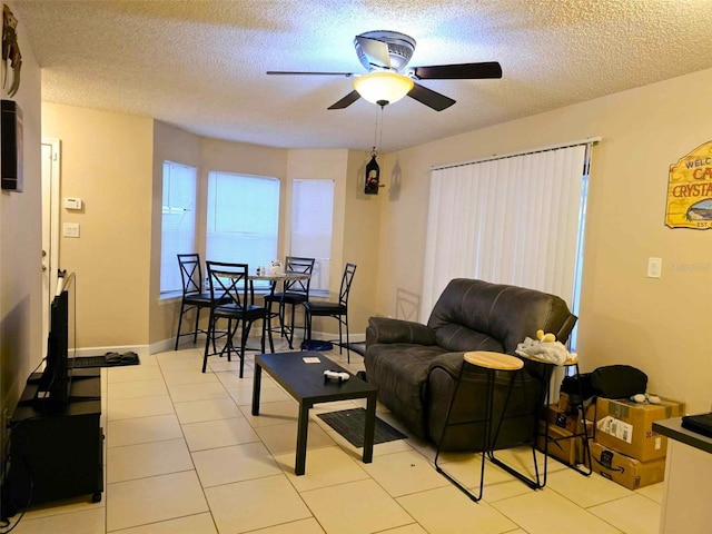 living room featuring a textured ceiling, ceiling fan, and light tile patterned flooring