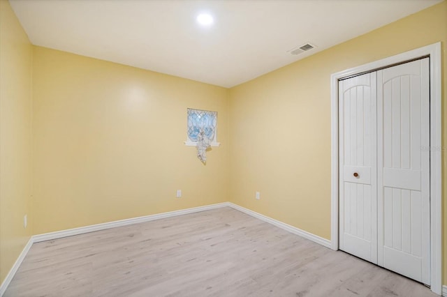 unfurnished bedroom featuring a closet and light wood-type flooring