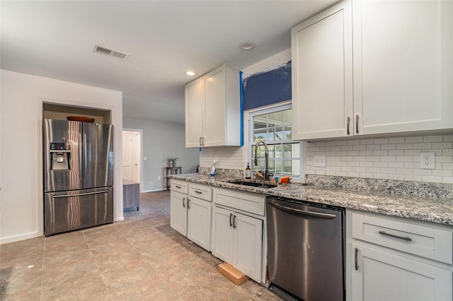 kitchen featuring white cabinets, sink, light stone countertops, tasteful backsplash, and stainless steel appliances