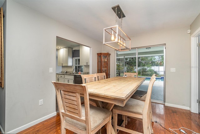 dining room with dark wood-type flooring and a chandelier