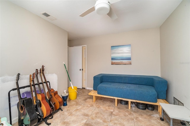 living area with light tile patterned floors and ceiling fan