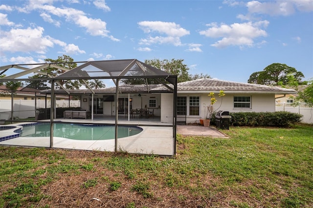 rear view of property featuring a lawn, ceiling fan, a lanai, a fenced in pool, and a patio