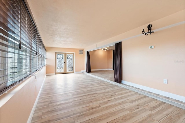 unfurnished room with french doors and light wood-type flooring