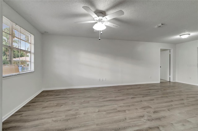 unfurnished room with hardwood / wood-style flooring, ceiling fan, and a textured ceiling