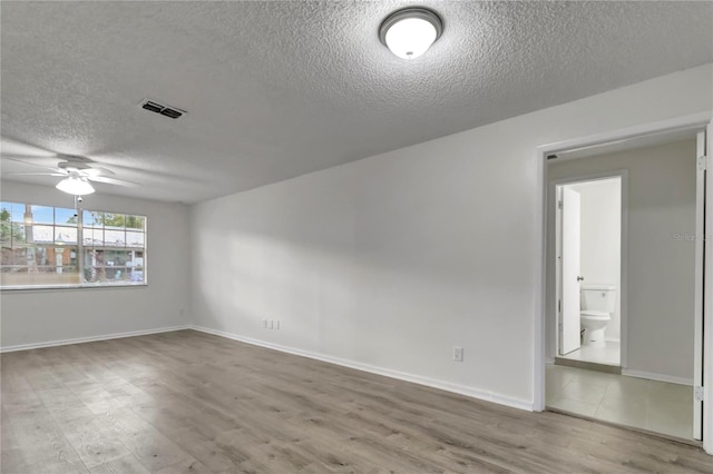 unfurnished room featuring ceiling fan, wood-type flooring, and a textured ceiling