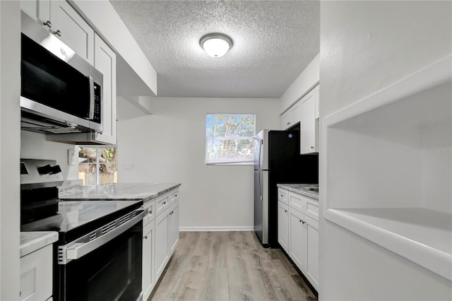 kitchen featuring a healthy amount of sunlight, white cabinetry, and appliances with stainless steel finishes