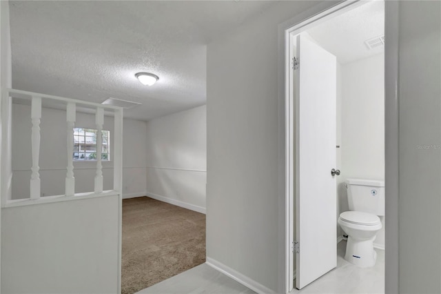 bathroom with toilet and a textured ceiling