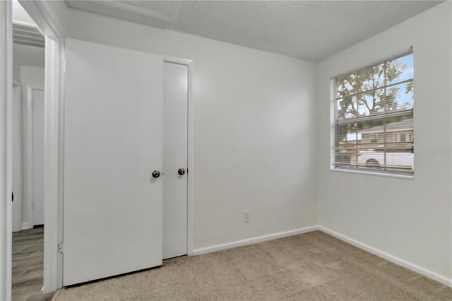 unfurnished bedroom with light colored carpet