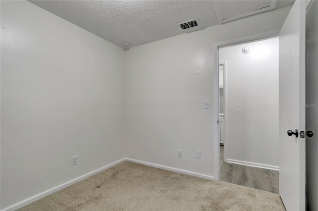 carpeted spare room with a textured ceiling