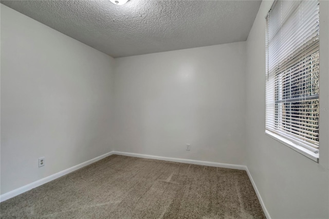 carpeted spare room featuring a textured ceiling