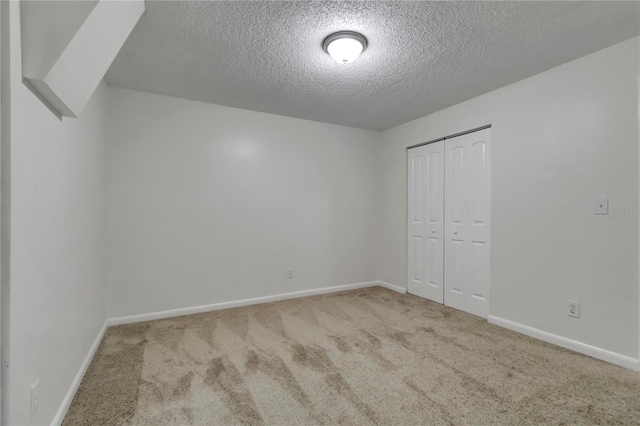 unfurnished bedroom with carpet floors, a textured ceiling, and a closet