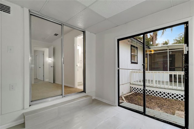 interior space with a drop ceiling and light tile patterned flooring