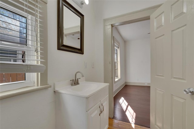 bathroom featuring a healthy amount of sunlight, wood-type flooring, and sink