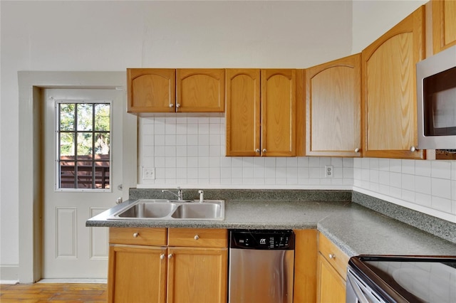 kitchen featuring backsplash, stainless steel appliances, light hardwood / wood-style flooring, and sink