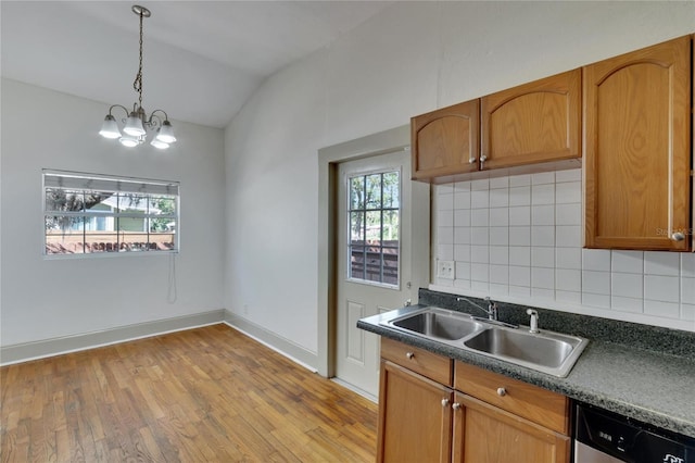 kitchen featuring sink, an inviting chandelier, stainless steel dishwasher, lofted ceiling, and decorative backsplash