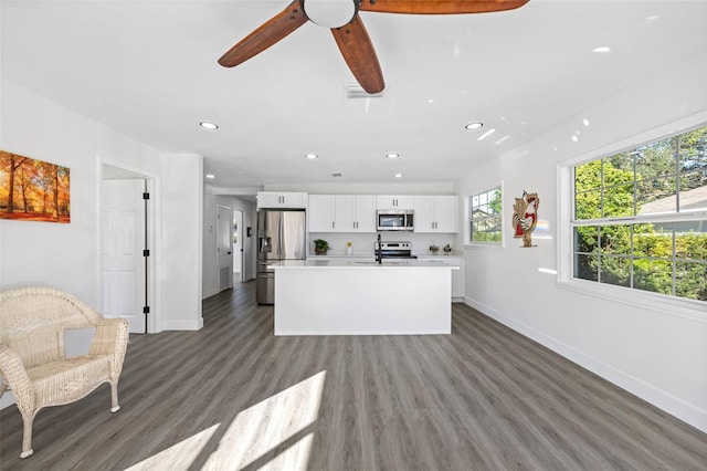 unfurnished living room featuring dark hardwood / wood-style flooring, ceiling fan, and sink