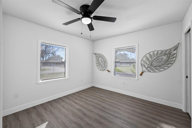 spare room with dark hardwood / wood-style floors, ceiling fan, and a wealth of natural light