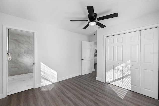 unfurnished bedroom featuring a closet, dark hardwood / wood-style flooring, ensuite bathroom, and ceiling fan