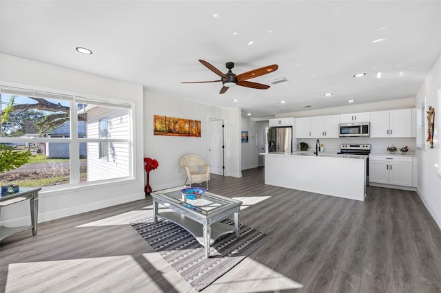 living room with ceiling fan, sink, a healthy amount of sunlight, and dark hardwood / wood-style floors