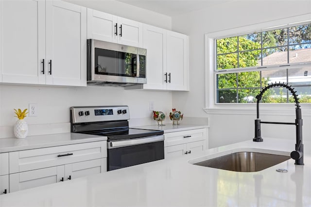 kitchen featuring white cabinets, stainless steel appliances, and sink