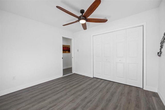 unfurnished bedroom with dark hardwood / wood-style flooring, a closet, and ceiling fan