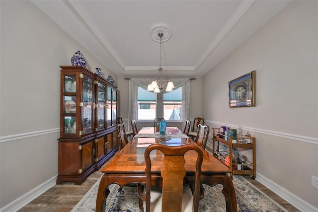 dining room featuring a raised ceiling, crown molding, dark hardwood / wood-style floors, and a notable chandelier