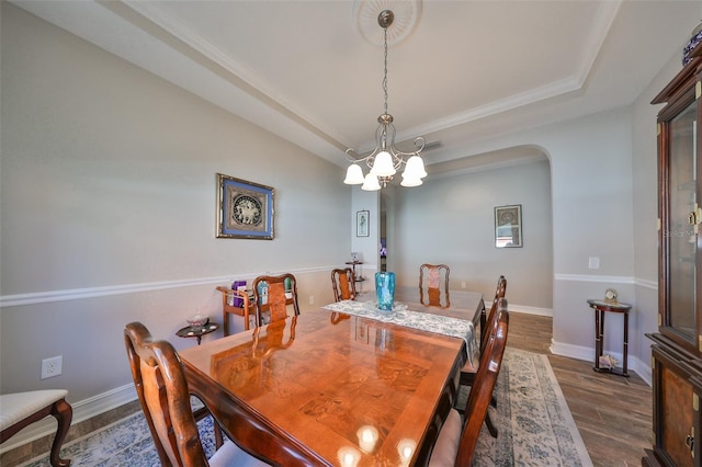 13230 Fawn Lily Dr, Riverview, FL 33579 - dining room with a chandelier, dark wood finished floors, arched walkways, baseboards, and a raised ceiling