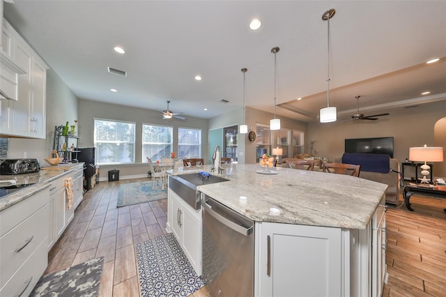 kitchen with white cabinetry, a center island with sink, stainless steel dishwasher, and light wood-type flooring