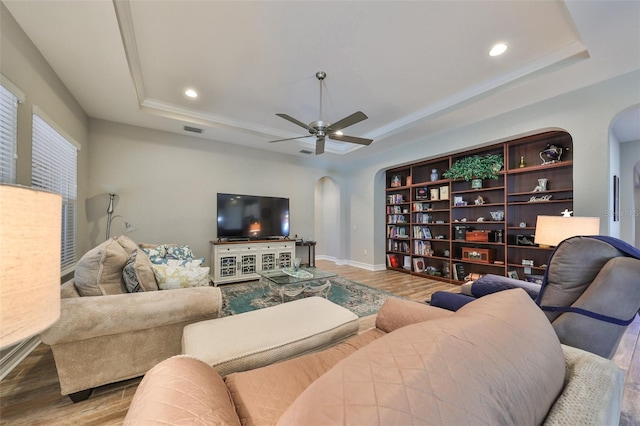 living room featuring light wood-type flooring and a tray ceiling