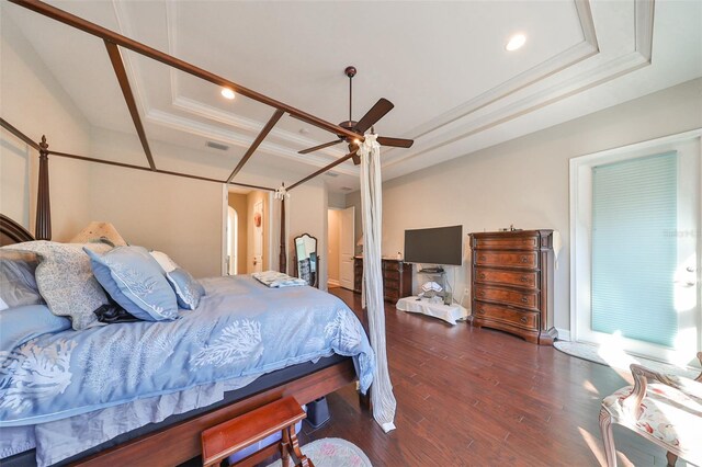 bedroom with a raised ceiling, ceiling fan, dark hardwood / wood-style flooring, and crown molding