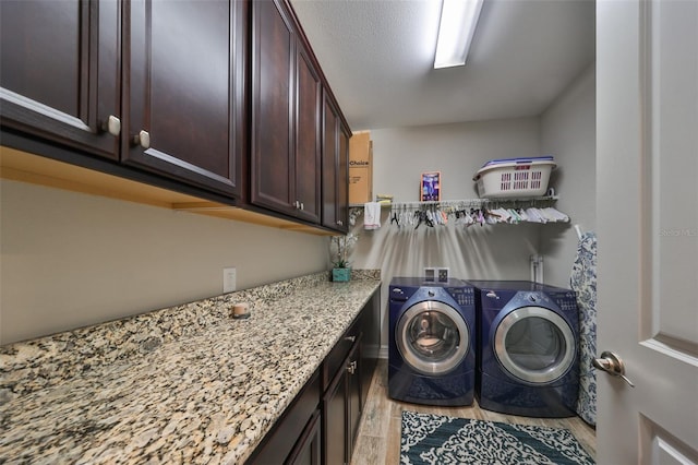 washroom featuring separate washer and dryer, cabinets, and light hardwood / wood-style floors