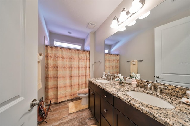 bathroom with hardwood / wood-style flooring, a shower with curtain, toilet, and vanity