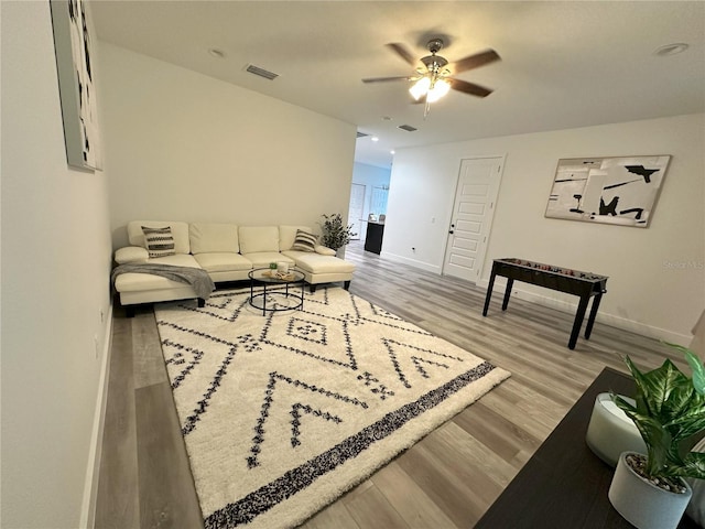 living room with light hardwood / wood-style flooring and ceiling fan