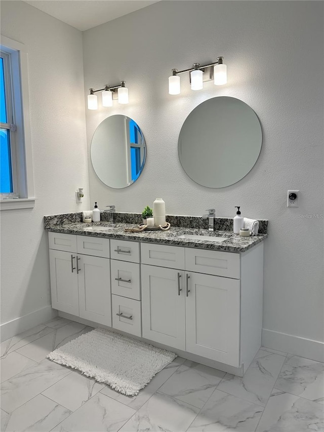 3208 Deleuil Ave, Tampa, FL 33610 - bathroom with baseboards, double vanity, and marble look tiles
