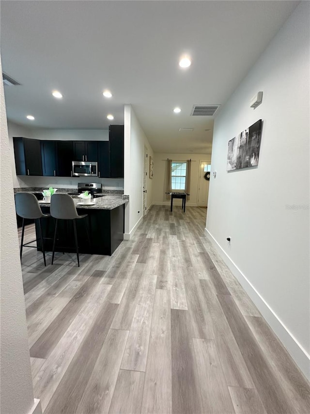 3208 Deleuil Ave, Tampa, FL 33610 - kitchen featuring appliances with stainless steel finishes, dark cabinets, light wood-type flooring, baseboards, and recessed lighting