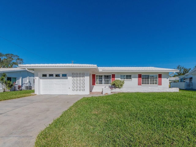 single story home with a front lawn, central AC unit, and a garage