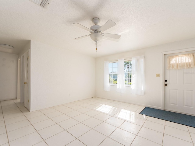 tiled entryway featuring ceiling fan and a textured ceiling