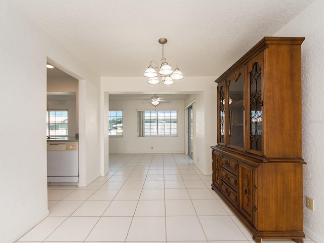 tiled dining space featuring ceiling fan with notable chandelier