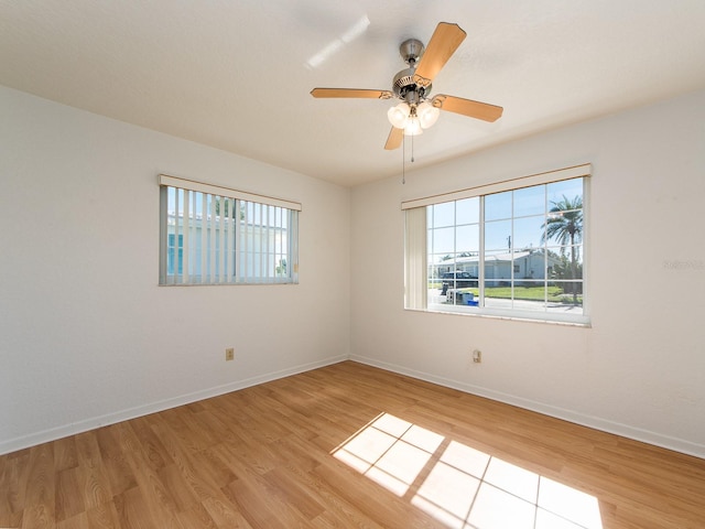 empty room with ceiling fan and light hardwood / wood-style flooring