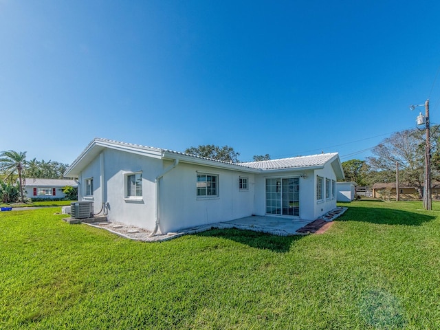 back of property with a lawn, cooling unit, and a patio