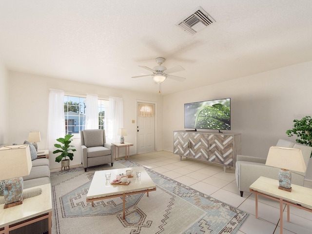 living room featuring ceiling fan, light tile patterned floors, and a textured ceiling