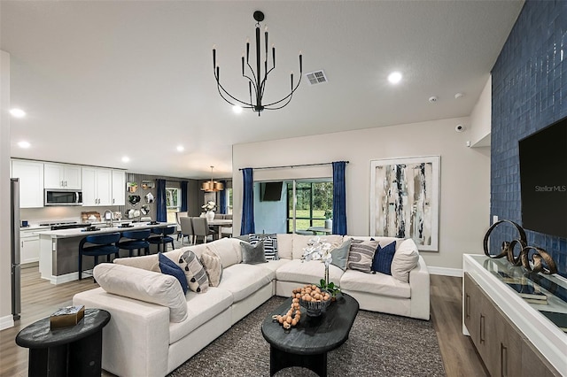 living room featuring sink, wood-type flooring, and a chandelier