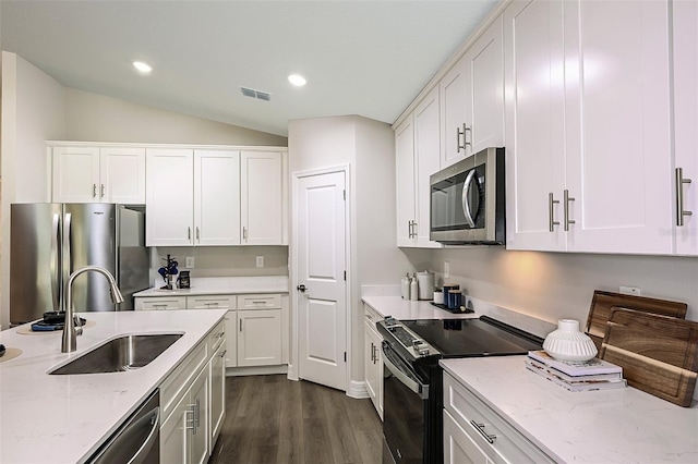 kitchen with light stone countertops, sink, white cabinets, and appliances with stainless steel finishes