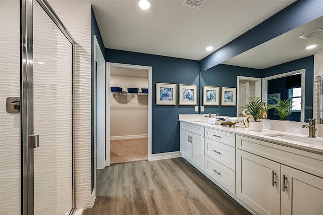 bathroom featuring a shower with door, wood-type flooring, and vanity