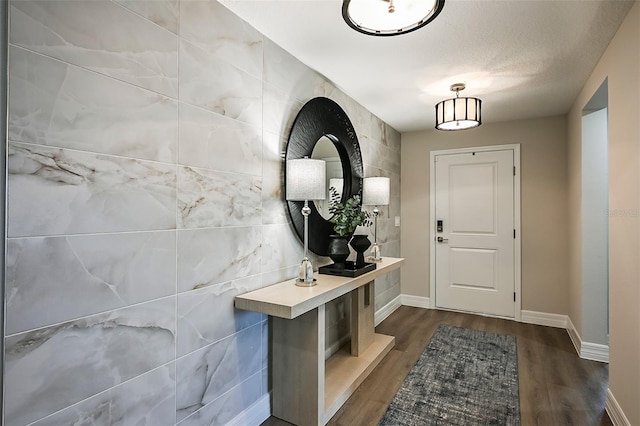 entryway featuring dark wood-type flooring and a textured ceiling