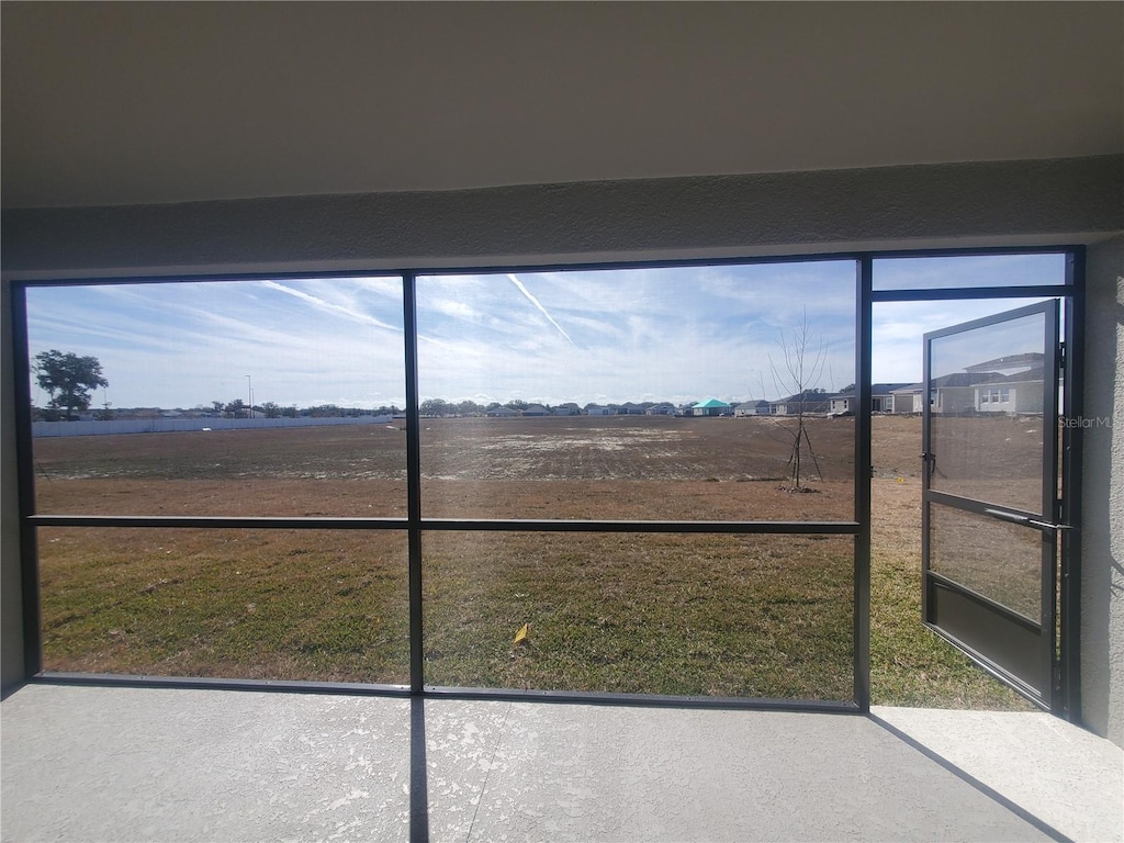 unfurnished sunroom featuring a rural view