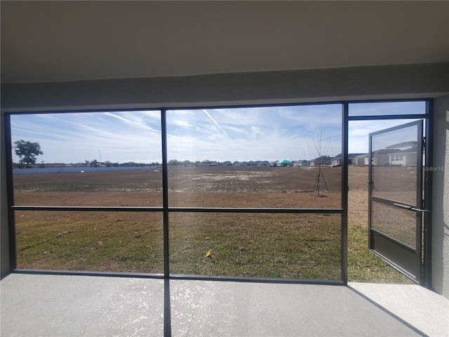 unfurnished sunroom featuring a rural view