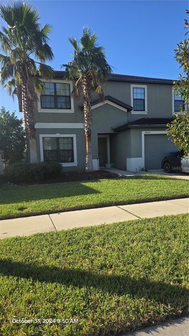 view of front of property featuring a garage and a front lawn